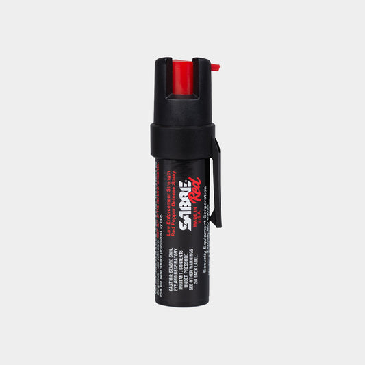 A light gray background product photo of the Sabre Red Compact Pepper Spray with clip attachment.